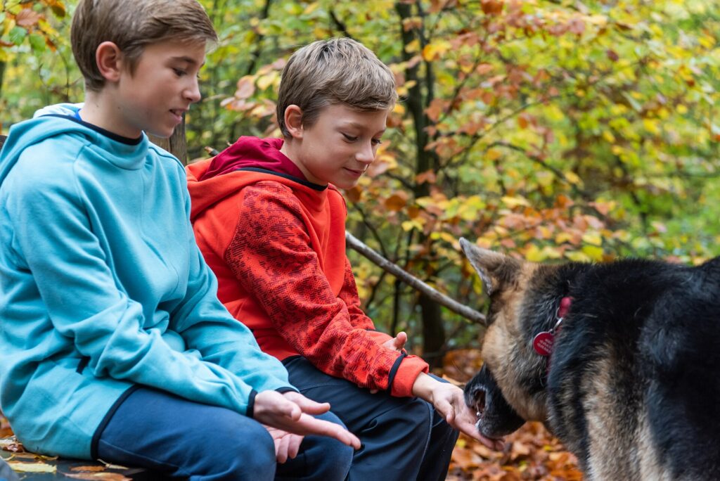 Children sharing a moment with their dog in nature