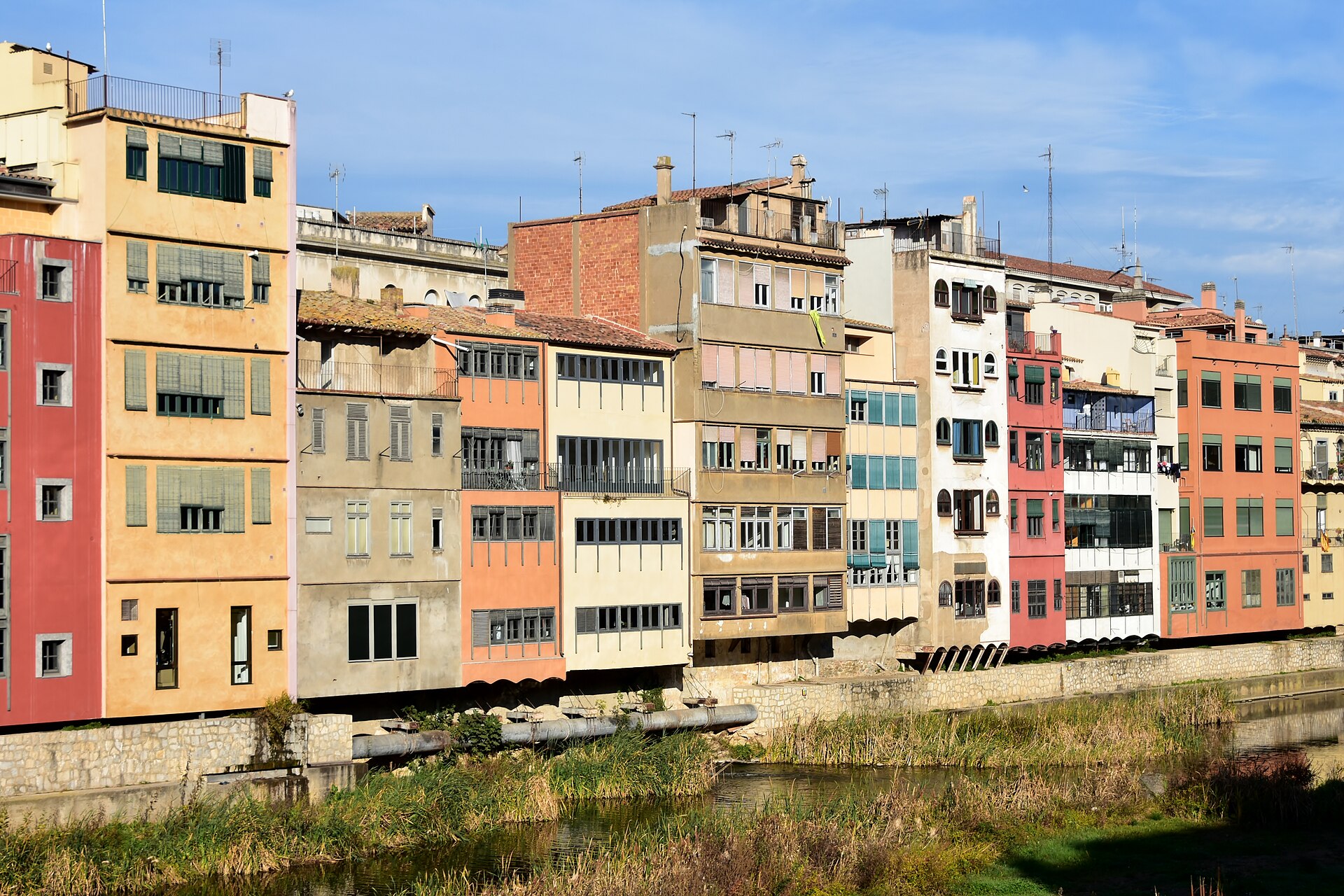 Fachadas amarelas, cor-de-rosa e ocres das casas junto ao rio Onyar em Girona