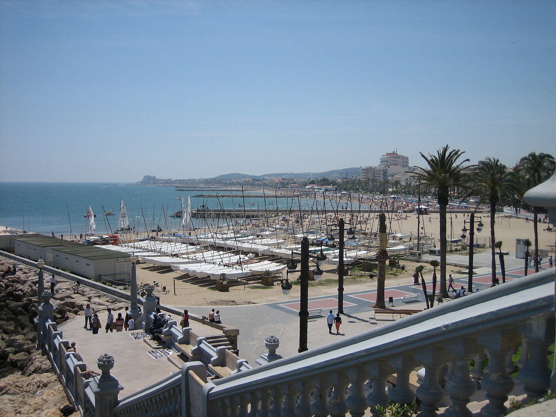Embarcações, palmeiras e passeio junto ao porto de Sitges
