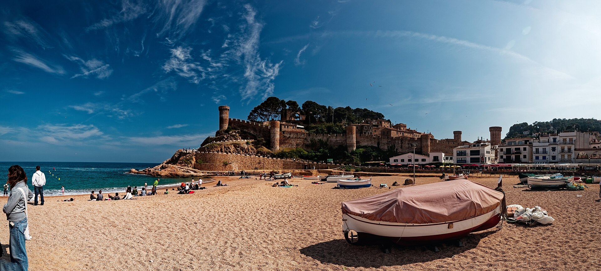 Barco na areia da Platja Gran com as muralhas de Tossa de Mar ao fundo
