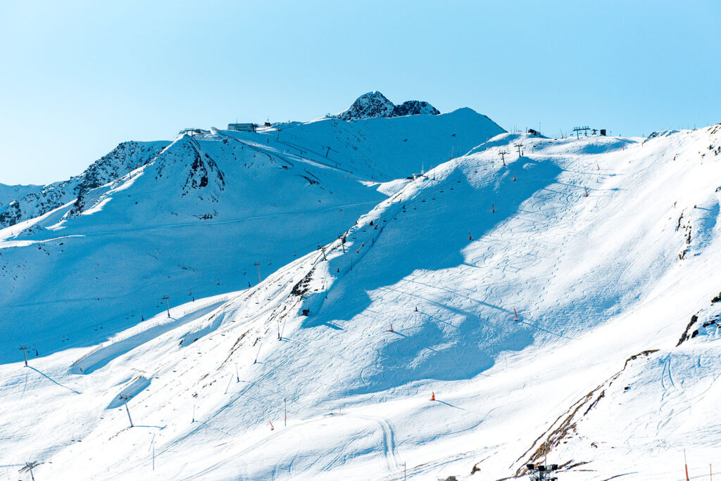 Snow-covered ski slopes and lifts in a mountain landscape