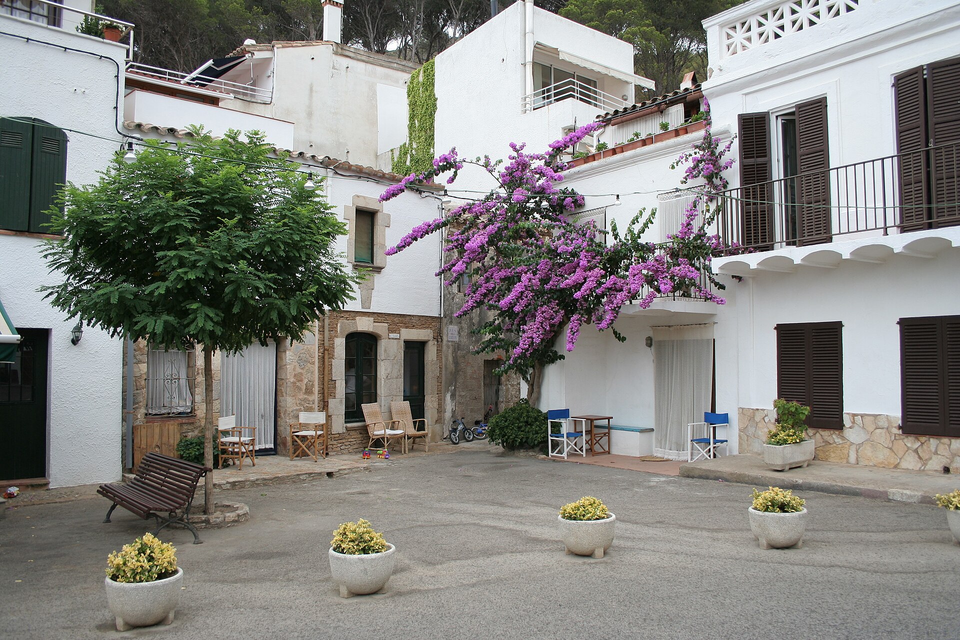 Casas blancas y flores en una pequeña plaza de Sa Tuna en Begur